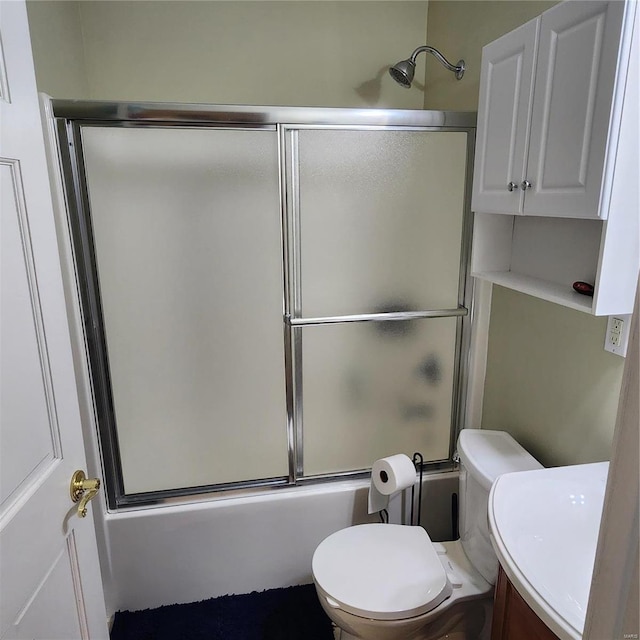 bathroom with toilet and shower / bath combination with glass door