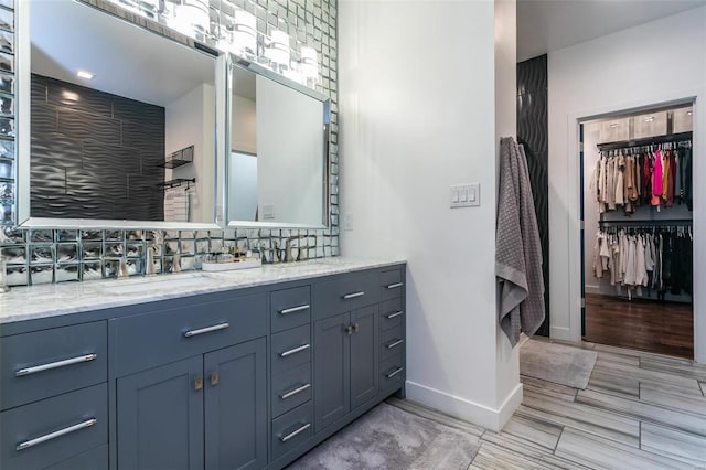 bathroom featuring hardwood / wood-style floors, vanity, and backsplash