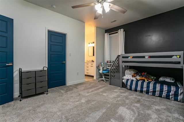 carpeted bedroom featuring ceiling fan and ensuite bath