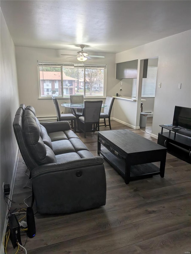 living room with dark wood-type flooring and ceiling fan