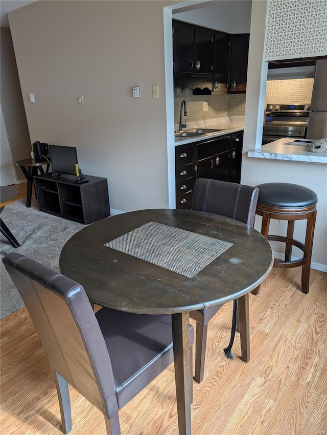 dining room with light wood-type flooring and sink