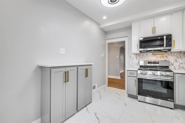 kitchen featuring backsplash, stainless steel appliances, and gray cabinetry