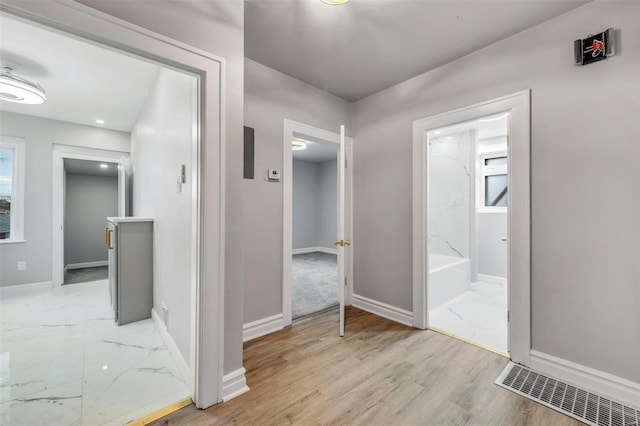 hallway featuring light hardwood / wood-style flooring and a wealth of natural light