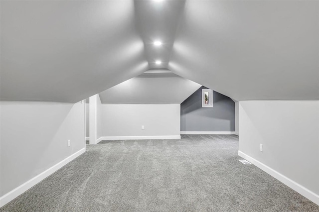 additional living space featuring lofted ceiling and carpet floors