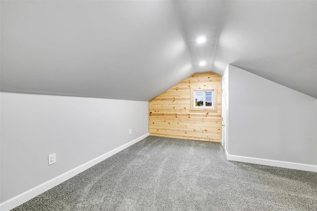 bonus room featuring wooden walls, carpet floors, and lofted ceiling