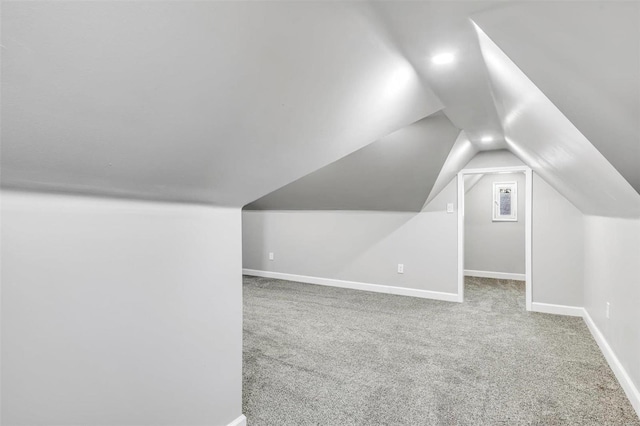 additional living space featuring carpet and vaulted ceiling