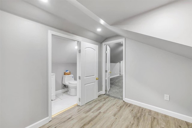 interior space with lofted ceiling and light hardwood / wood-style flooring