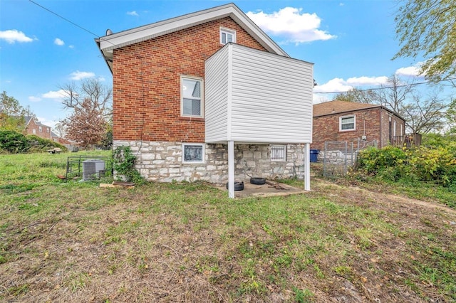 rear view of house featuring a yard and central AC