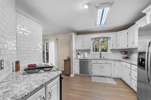 kitchen featuring tasteful backsplash, white cabinets, sink, and stainless steel appliances