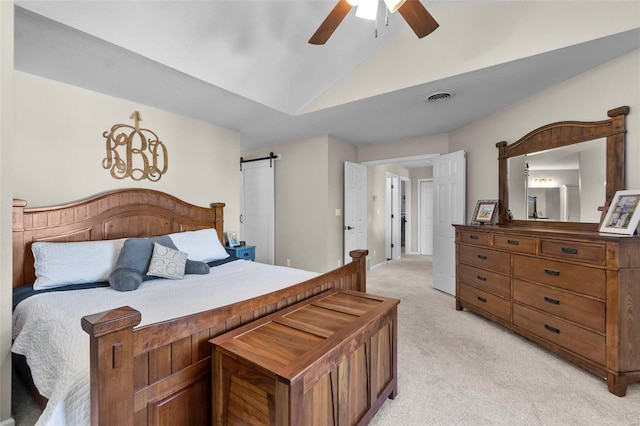 bedroom with light carpet, ceiling fan, vaulted ceiling, and a barn door