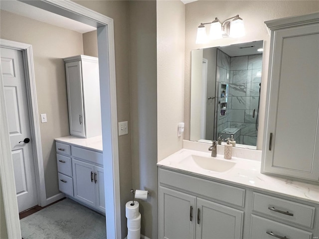 bathroom with vanity and a tile shower