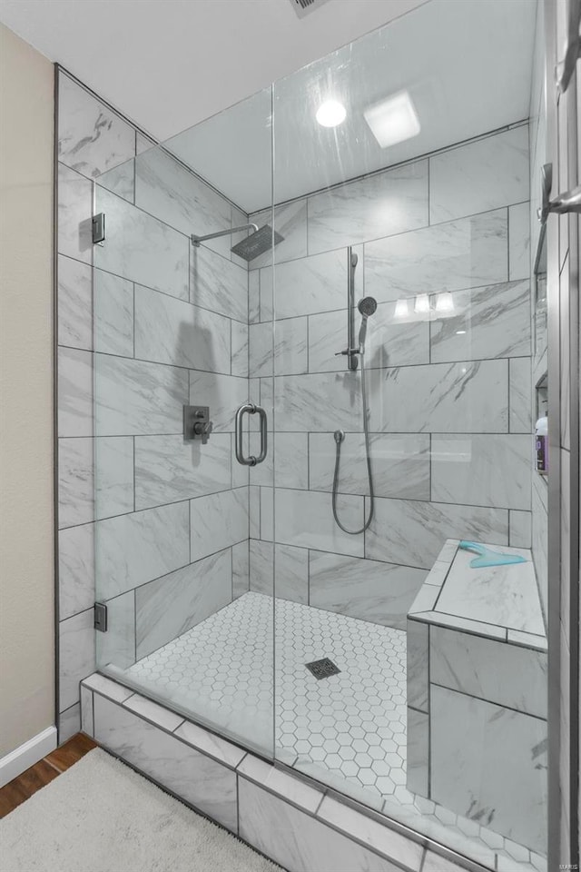 bathroom featuring wood-type flooring and an enclosed shower