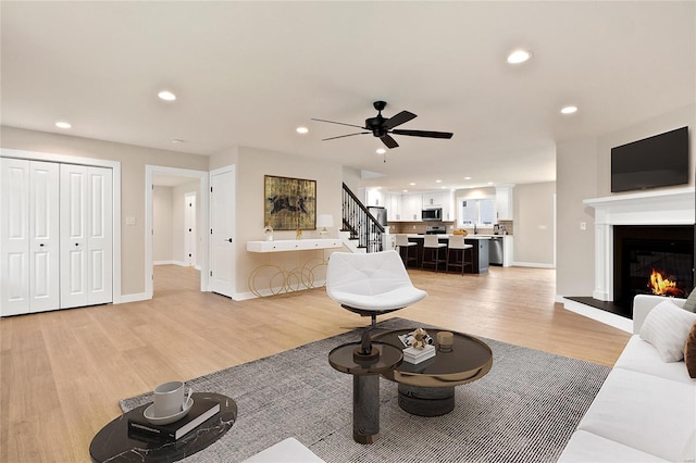 living room featuring ceiling fan and light hardwood / wood-style flooring