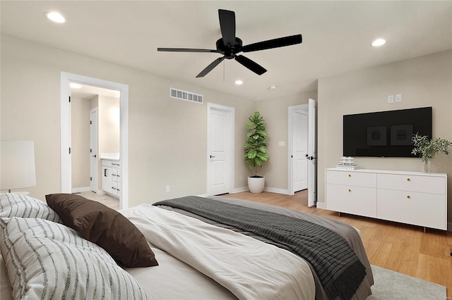 bedroom with light wood-type flooring, ceiling fan, and connected bathroom