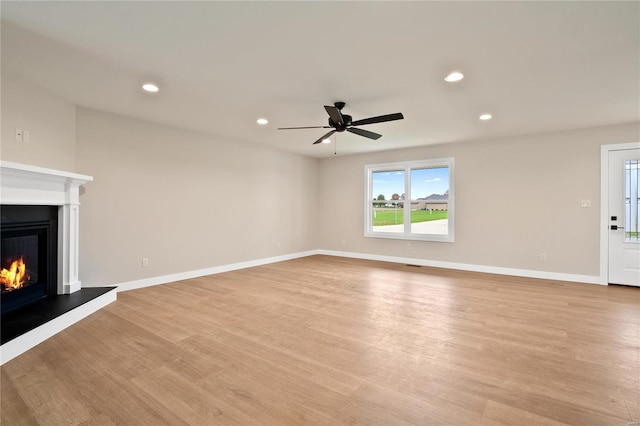 unfurnished living room with ceiling fan and light hardwood / wood-style flooring