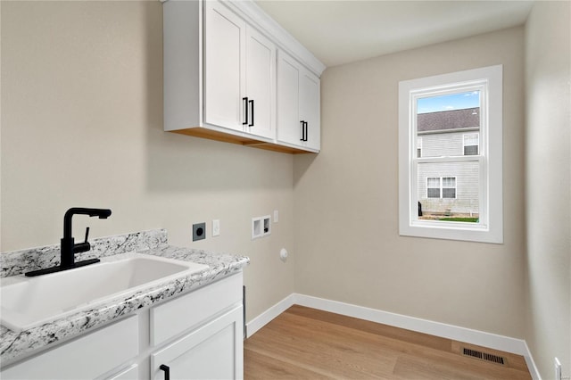 laundry area featuring cabinets, sink, hookup for a washing machine, light wood-type flooring, and hookup for an electric dryer