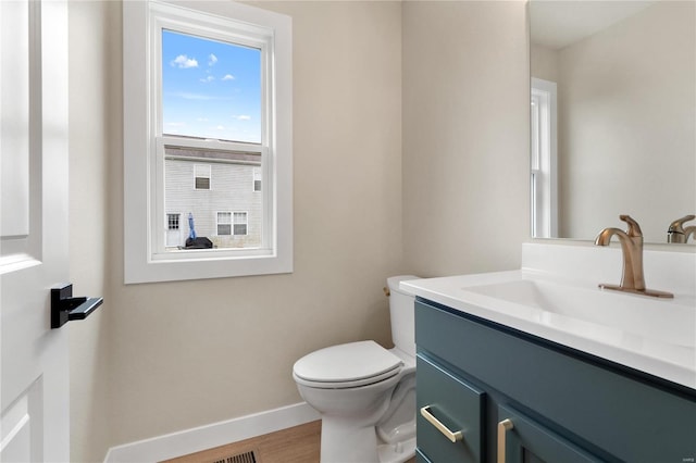 bathroom with hardwood / wood-style flooring, vanity, and toilet