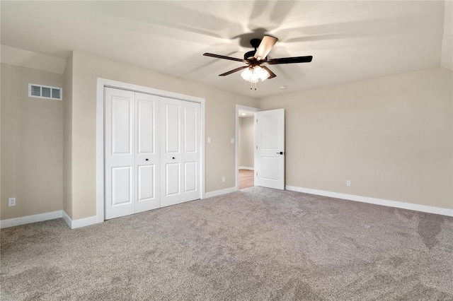 unfurnished bedroom with carpet flooring, ceiling fan, and a closet