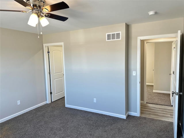 unfurnished bedroom with ceiling fan and dark carpet