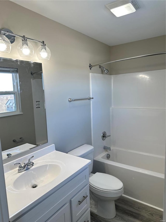 full bathroom featuring hardwood / wood-style flooring, tub / shower combination, toilet, and vanity