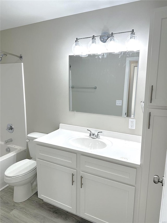 full bathroom with toilet, vanity, tub / shower combination, and hardwood / wood-style flooring