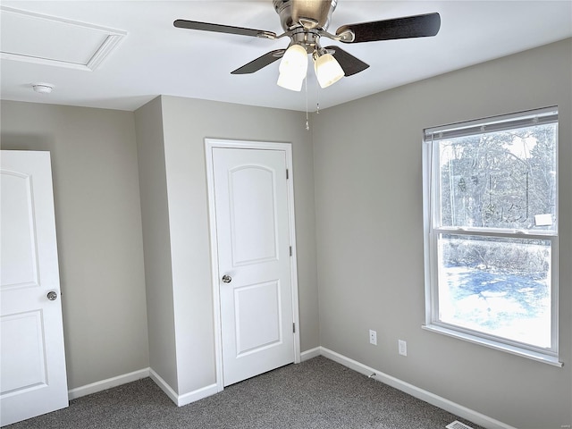 unfurnished bedroom featuring ceiling fan and dark carpet