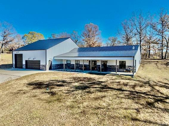 view of front of property featuring a front lawn, a garage, and a porch