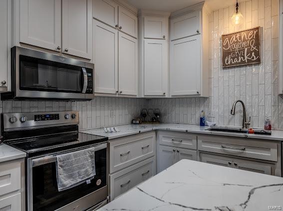 kitchen with white cabinetry, appliances with stainless steel finishes, and backsplash