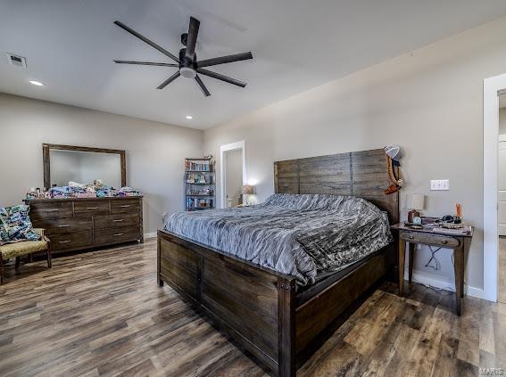 bedroom with dark hardwood / wood-style flooring and ceiling fan