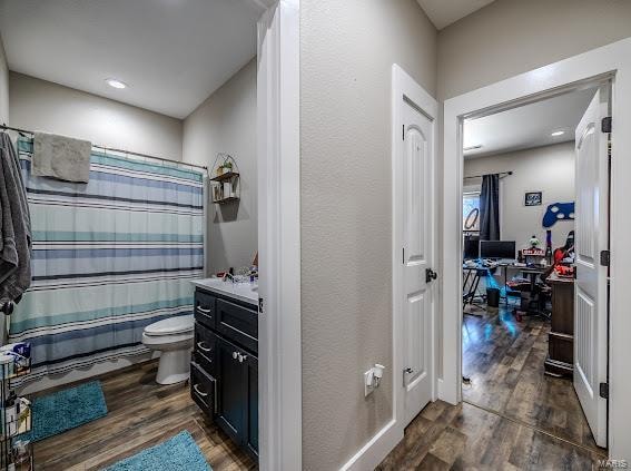 bathroom with wood-type flooring, vanity, and toilet