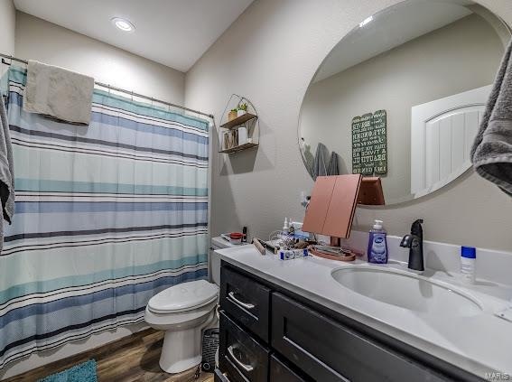 bathroom with wood-type flooring, vanity, and toilet