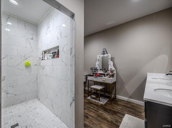 bathroom featuring vanity, hardwood / wood-style flooring, and a tile shower