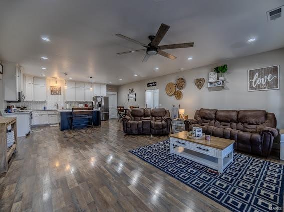 living room with wood-type flooring and ceiling fan