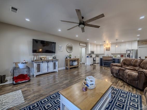 living room with hardwood / wood-style flooring and ceiling fan