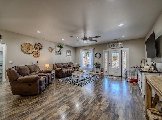 living room with dark wood-type flooring and ceiling fan