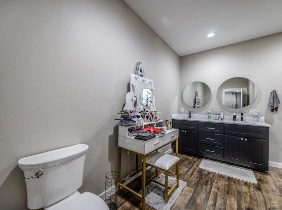 bathroom featuring toilet, vanity, and wood-type flooring