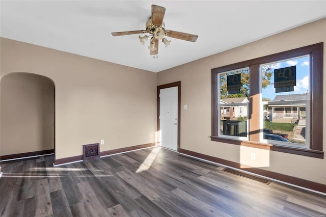 unfurnished room featuring dark wood-type flooring and ceiling fan