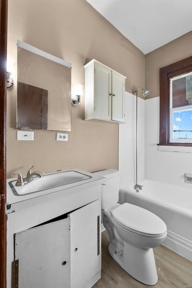 full bathroom with washtub / shower combination, wood-type flooring, toilet, and vanity