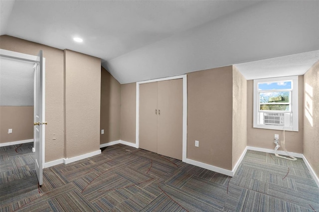 additional living space with dark colored carpet and lofted ceiling