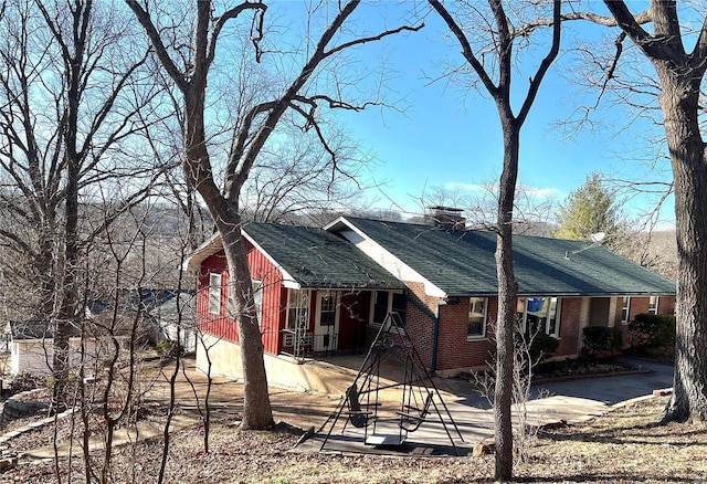 view of side of property featuring brick siding and a chimney