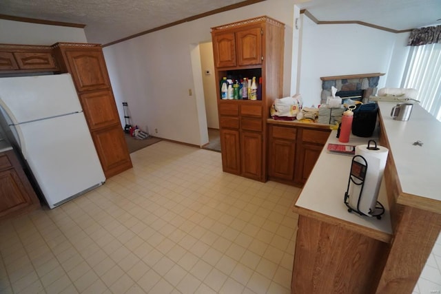 kitchen with a fireplace, a textured ceiling, white refrigerator, and crown molding