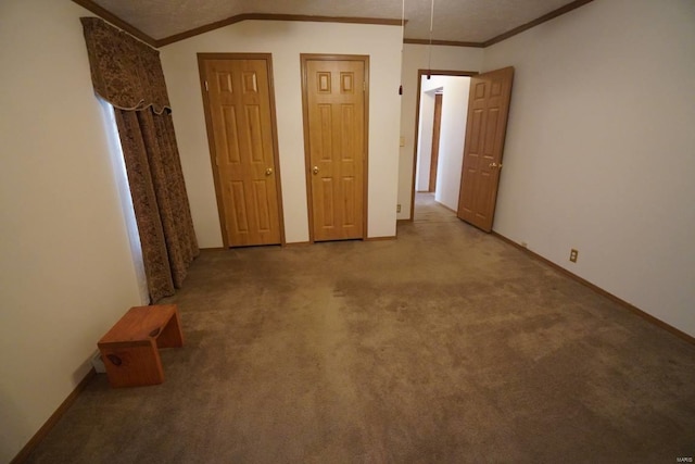 carpeted empty room featuring vaulted ceiling and ornamental molding