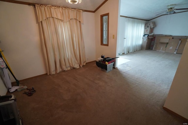 interior space with crown molding, vaulted ceiling, ceiling fan, and carpet floors