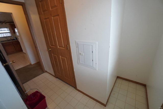 hallway with electric panel and light tile patterned floors