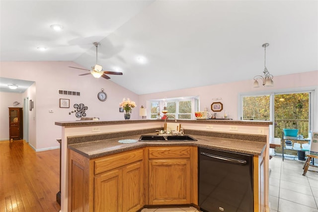 kitchen with lofted ceiling, dishwasher, sink, a kitchen island with sink, and light wood-type flooring