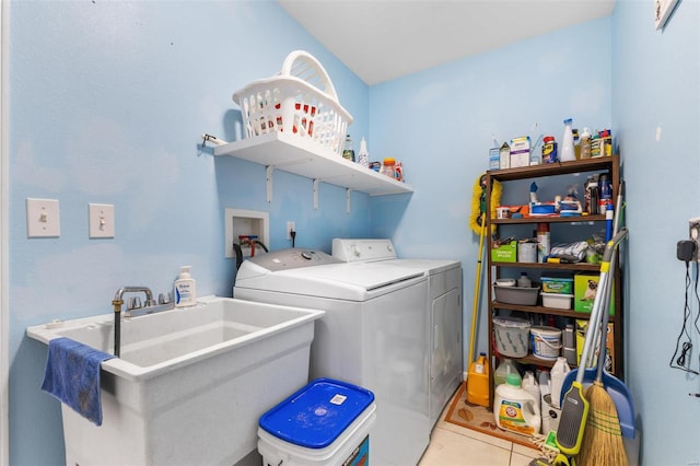 laundry area featuring light tile patterned flooring, sink, and independent washer and dryer