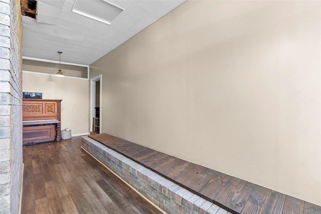 hallway with dark hardwood / wood-style floors and a towering ceiling