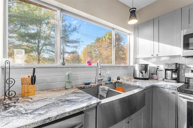 kitchen with decorative backsplash, decorative light fixtures, and plenty of natural light