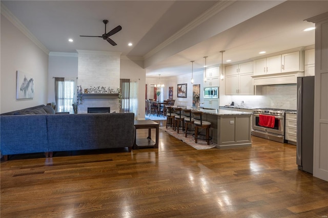 kitchen featuring appliances with stainless steel finishes, dark hardwood / wood-style flooring, a breakfast bar, and a kitchen island