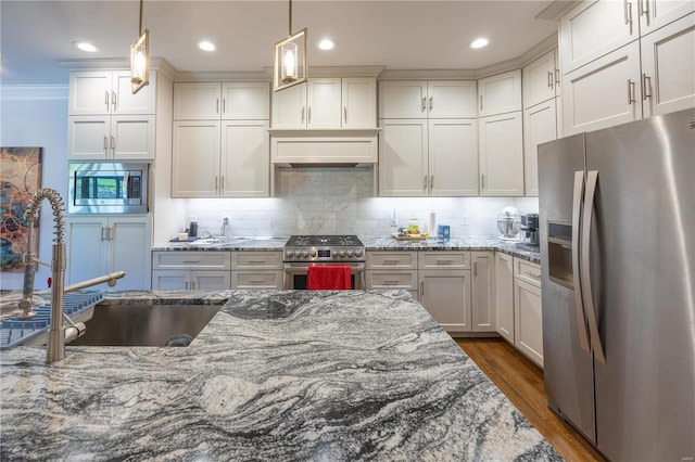 kitchen with stainless steel appliances, hanging light fixtures, ornamental molding, backsplash, and light stone countertops